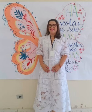 Aline em frente a mural com asas de borboleta